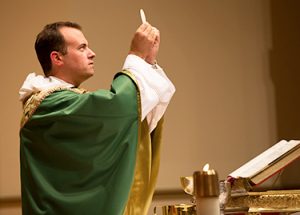 Father Cuddy holding the eucharist