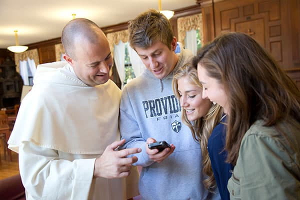 A Dominican priest helping students